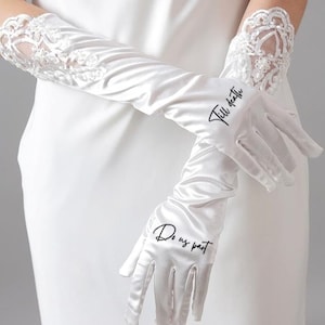 May include: A pair of white satin gloves with lace detailing. The gloves have the text "Till death" written on one glove and "Do us part" written on the other glove.
