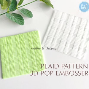 May include: A white plastic 3D pop embosser with a plaid pattern. The embosser is shown next to a green embossed piece of fondant. The text "PLAID PATTERN 3D POP EMBOSSER" is printed below the embosser.