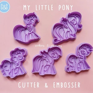 Puede incluir: Conjunto de cinco cortadores de galletas y estampadores My Little Pony de pl&aacute;stico morado. Los cortadores presentan diferentes dise&ntilde;os de ponis.