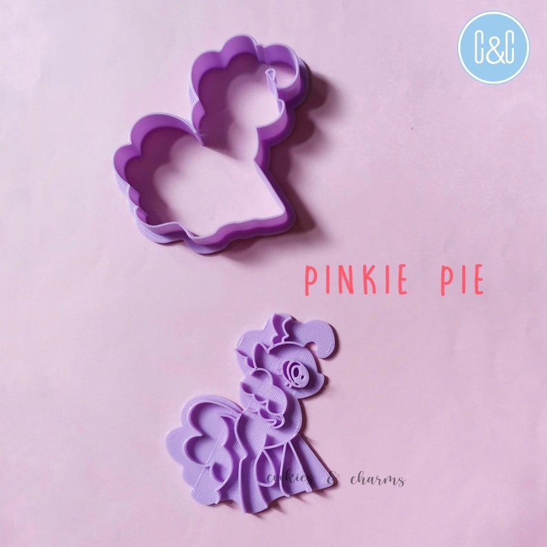 Puede incluir: Cortador de galletas de pl&aacute;stico morado con forma de Pinkie Pie de My Little Pony. El cortador est&aacute; en dos piezas, una para el contorno y otra para los detalles. El texto "Pinkie Pie" est&aacute; impreso debajo del cortador.