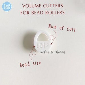 May include: White plastic volume cutter for bead rollers. The cutter has a number "15/2" and the text "cookies & charms" printed on it. The cutter is labeled with "Num of cuts" and "Bead size".