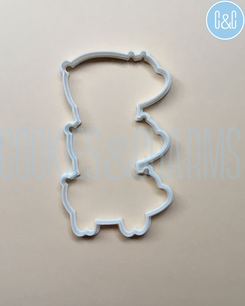 May include: White plastic cookie cutter shaped like a cartoon bear standing on its hind legs.