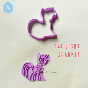 Puede incluir: Cortador de galletas de pl&aacute;stico morado en forma de Twilight Sparkle de My Little Pony. El cortador se muestra junto a una impresi&oacute;n de pl&aacute;stico morado m&aacute;s peque&ntilde;a del mismo dise&ntilde;o.