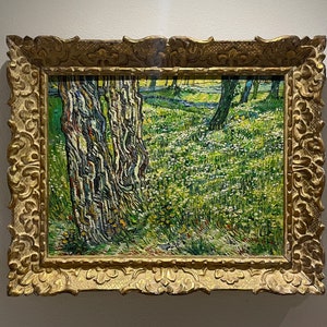 Op de afbeelding: Een schilderij in een gouden lijst toont een landschap met een veld vol witte bloemen en hoge, dunne bomen met getextureerde schors. Het schilderij is gemaakt in een stijl die doet denken aan Vincent van Gogh.