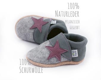 May include: Gray felt baby shoes with a purple star detail. The shoes are made of 100% natural leather and 100% wool.