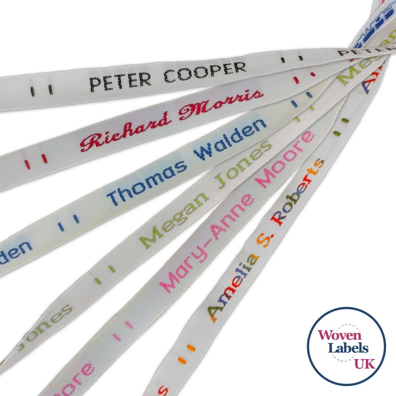 May include: Close-up of white woven labels with different names printed in colorful thread. The names include Peter Cooper, Richard Morris, Thomas Walden, Megan Jones, Mary-Anne Moore, and Amelia S. Roberts. The labels are arranged in a fan shape, with the top label partially obscured. The image includes the text "Woven Labels UK".