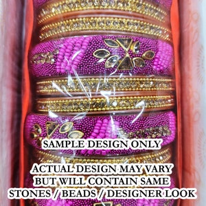 Puede incluir: Un conjunto de brazaletes de color rosa y dorado con piedras y cuentas decorativas. Los brazaletes est&aacute;n apilados y se muestran en una caja. El texto en la caja dice "SAMPLE DESIGN ONLY ACTUAL DESIGN MAY VARY BUT WILL CONTAIN SAME STONES/BEADS/DESIGNER LOOK 100% SATISFACTION GUARANTEED".