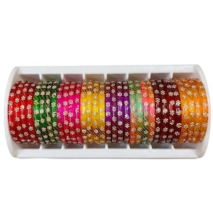 May include: A set of multi-coloured bangles arranged in a white plastic organiser. The bangles feature a translucent finish in shades of red, green, pink, yellow, purple, orange, and dark red, each decorated with a repeating pattern of small white flowers.