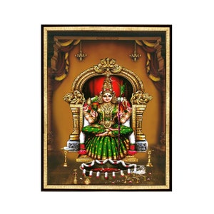 Puede incluir: Una pintura enmarcada de una diosa hindú sentada en un trono. Lleva un sari verde y dorado y una corona. Sostiene un bastón en su mano derecha y una copa en su mano izquierda. El fondo es de color dorado con acentos rojos y dorados.