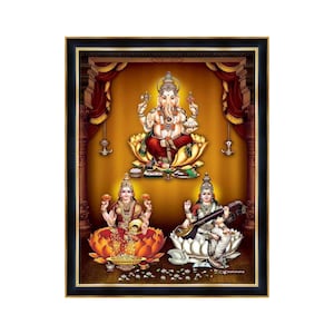Puede incluir: Una impresión enmarcada de tres deidades hindúes: Ganesha, Lakshmi y Saraswati. Ganesha está sentado en una flor de loto y sostiene un dulce, un modak, en su trompa. Lakshmi está sentada en una flor de loto y sostiene una olla de monedas de oro. Saraswati está sentada en una flor de loto y sostiene una vina, un instrumento musical de cuerda.