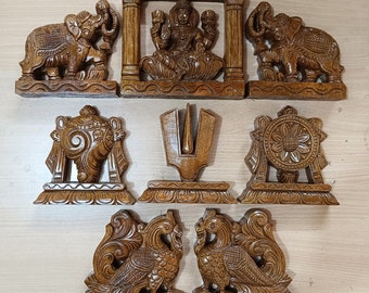 Puede incluir: Conjunto de diez figuras hindúes de madera, que incluyen una diosa de cuatro brazos, dos elefantes, una concha, un tridente, una rueda y dos pavos reales. Las figuras están talladas en un estilo tradicional y están pintadas en tonos marrones.