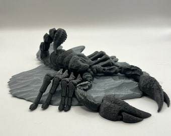 Articulated Scorpion desk toy with rock display.