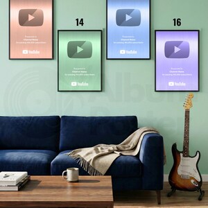 Puede incluir: Cuatro premios enmarcados de YouTube Play Button en tonos cobre, verde, azul y morado cuelgan de una pared verde claro. Los premios est&aacute;n encima de un sof&aacute; azul oscuro, una mesa de centro de madera y una guitarra.