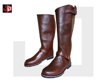 May include: A pair of brown leather riding boots. The boots are knee-high with a buckle strap around the ankle and another at the top. The soles are black with a white stripe.