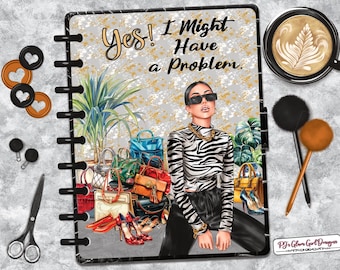 May include: A planner with a fashion illustration featuring a woman in sunglasses and a zebra-print top, surrounded by handbags and shoes. The text reads "Yes! I Might Have a Problem." Accessories include a coffee cup, pens, and decorative paper clips.