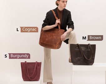 Puede incluir: Tres bolsos tote de cuero en diferentes tamaños y colores: un bolso grande color coñac, un bolso mediano marrón y un bolso pequeño burdeos.