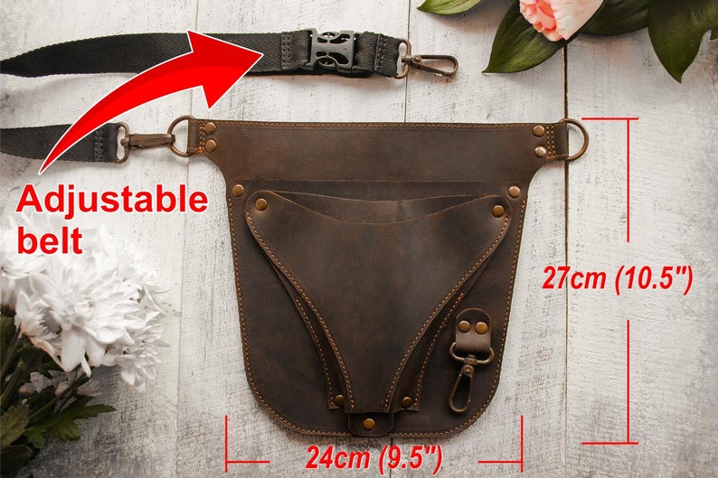 May include: Brown leather tool belt with an adjustable strap and multiple pockets. The belt measures 27 inches tall and 9.5 inches wide.