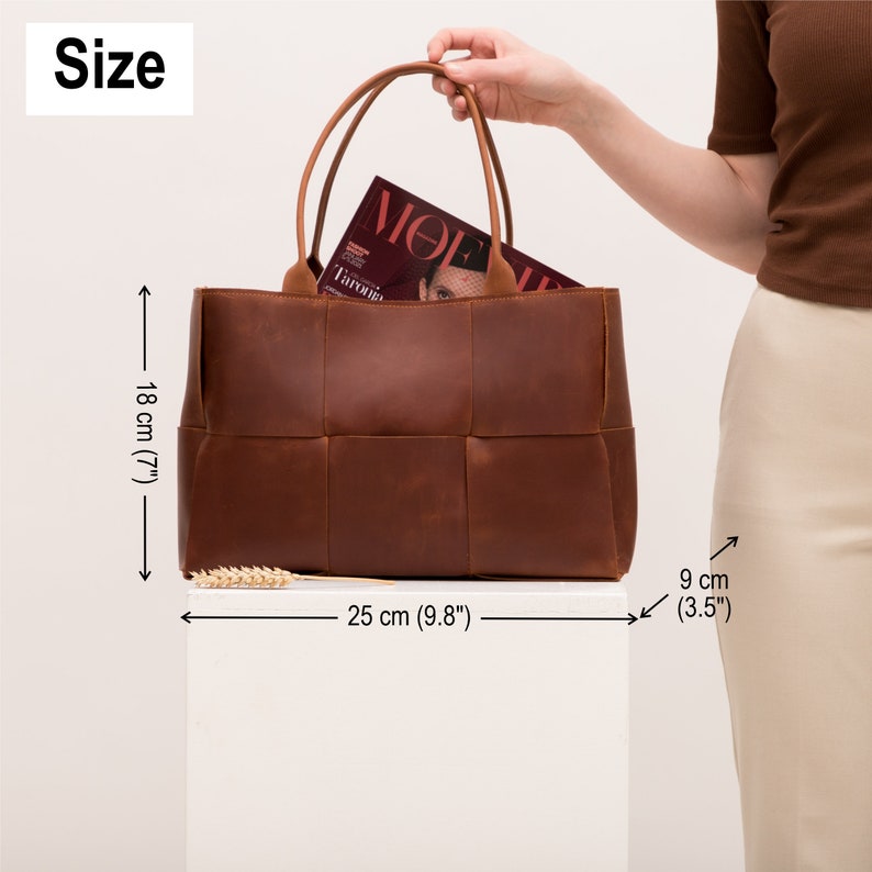 May include: A brown leather tote bag with a woven design. The bag is 9.8 inches wide, 7 inches tall, and 3.5 inches deep.