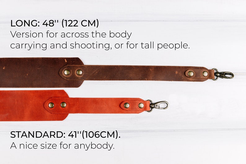 Peut inclure: Deux sangles de cam&eacute;ra en cuir, l'une brune et l'autre orange, avec des fermoirs m&eacute;talliques. La sangle brune est &eacute;tiquet&eacute;e "LONG: 48" (122 CM)" et la sangle orange est &eacute;tiquet&eacute;e "STANDARD: 41" (106CM)."