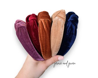 May include: Six velvet headbands in different colors: purple, burgundy, brown, beige, navy blue. The headbands are knotted and are held in a hand. The text "grace and given" is written below the headbands.