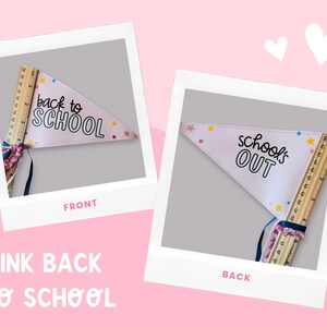 以下が含まれることがあります： 「back to SCHOOL」と「school's OUT」の文字が入ったピンク色のペナントフラッグ。木製の定規に付けられ、カラフルな星とリボンで飾られています。画像はピンク色の背景にあり、2つの白いハートが描かれています。