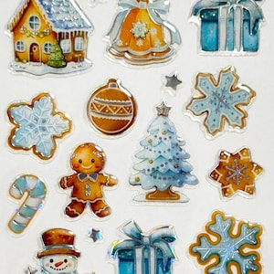 May include: A sheet of Christmas-themed stickers featuring various designs. Includes houses, bells, snowflakes, gingerbread men, snowmen, presents, Christmas trees, and candy canes. The stickers have a shiny, iridescent finish with gold, blue, and white accents.