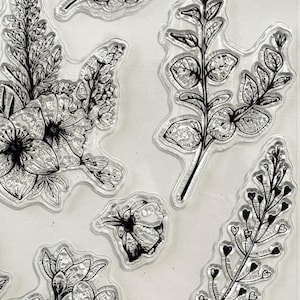 Op de afbeelding: Een set van 10 transparante stempels met bloem- en bladmotieven. De stempels zijn perfect om een ​​toets van elegantie toe te voegen aan je knutselprojecten.