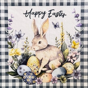 May include: A decorative Easter napkin with a watercolor illustration. It features a bunny surrounded by colorful eggs and flowers, with the text "Happy Easter" in script. The background has a black and white checkered pattern.