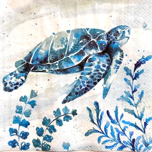 May include: A square paper napkin featuring a watercolor illustration of a sea turtle swimming among blue aquatic plants. The turtle is rendered in shades of deep blue and navy with textured shell patterns, set against a light, neutral background.