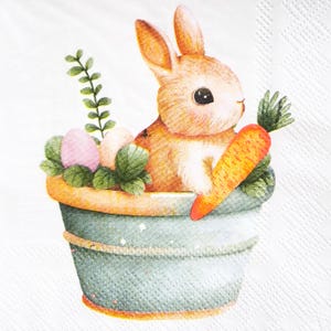 May include: A watercolor illustration of a bunny in a blue pot with a carrot and Easter eggs. The bunny is light brown with white fur and large black eyes. The pot has a rope detail and is filled with green leaves and pink and white eggs.