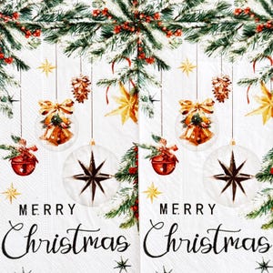 May include: White Christmas-themed paper napkins with a festive design. The napkins feature hanging ornaments, including bells, stars, and pinecones, with the words "Merry Christmas" in elegant script. Green pine branches and red berries complete the holiday look.