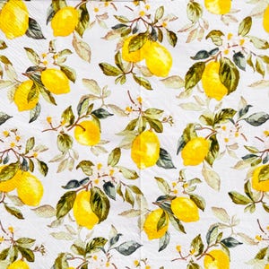 May include: White paper napkins with a repeating pattern of yellow lemons, green leaves, and white blossoms. The lemons are clustered on branches, creating a fresh, summery design. Ideal for kitchen or dining decor.