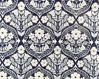 May include: A fabric featuring a repeating pattern of white floral motifs set against a dark navy blue background. The design consists of symmetrical bouquets of flowers and leaves enclosed within interlocking, curved, leaf-shaped frames.