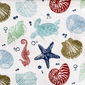 May include: White paper napkin with a repeating pattern of sea creatures and shells in shades of blue, green, red, and brown. The design includes a starfish, seahorse, turtle, and various shell shapes, with small blue bubbles scattered throughout.