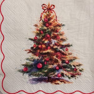 May include: A Christmas-themed napkin with a detailed illustration of a decorated Christmas tree. The tree is adorned with red ornaments and a red bow at the top. The napkin has a white background with a red scalloped border.