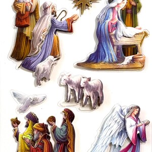 May include: A set of seven la petites dimensional stickers featuring a nativity scene with figures of Mary, Joseph, the baby Jesus in a manger, an angel, three wise men, a star, a dove, and lambs, all rendered in colorful, detailed illustrations.