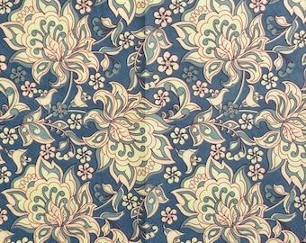 May include: A repeating floral pattern in shades of blue, cream, and peach. Large stylized flowers and smaller blossoms are arranged across the surface. The design has a vintage, slightly faded appearance, suggesting a classic textile or wallpaper.