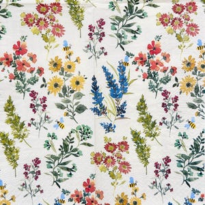 Op de afbeelding: Wit papier met een bloemenpatroon met aquarel illustraties van rode, gele en blauwe bloemen, groene bladeren en kleine bijen. Het ontwerp wordt herhaald, waardoor een botanisch thema ontstaat.