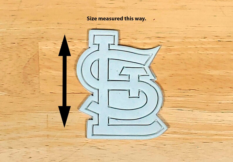 K&ouml;nnte beinhalten: Wei&szlig;er Plastik-Ausstecher in Form des Logos der St. Louis Cardinals. "Size measured this way." steht &uuml;ber dem Ausstecher.