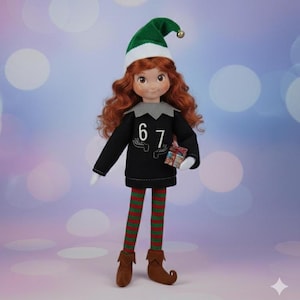 May include: An elf doll with a green hat and white trim, and a gold bell. The doll has red curly hair, a black top with the numbers "67", and red and green striped legs. It holds a small gift.