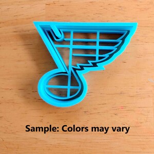 Może przedstawiać: Niebieska plastikowa foremka do ciasteczek w kształcie logo drużyny hokejowej St. Louis Blues. Logo przedstawia nutę z skrzydłem na g&oacute;rze.