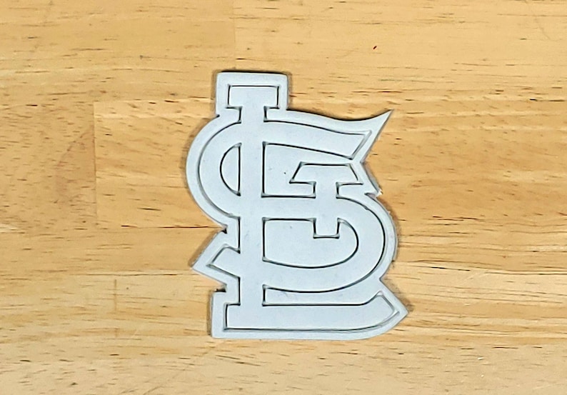 K&ouml;nnte beinhalten: Wei&szlig;er Plastik-Ausstecher in Form des Logos des Baseballteams St. Louis Cardinals.