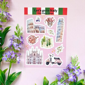 Könnte beinhalten: Ein Bogen Aufkleber mit italienischen Illustrationen. Die Aufkleber zeigen das Kolosseum, den Schiefen Turm von Pisa, eine Gondel, einen Roller und den Text "Let's go to Italy". Die Aufkleber befinden sich auf einem rosa Hintergrund.