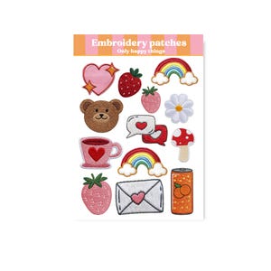Op de afbeelding: Een vel geborduurde patches met diverse ontwerpen, waaronder een roze hart met een gouden ster, een aardbei, een regenboog, een teddybeer, een bloem, een paddenstoel, een theekopje, een tekstballon met een hart, een aardbei, een envelop met een hart en een blikje sinaasappelsoda. De tekst "Embroidery patches" en "Only happy things" staat bovenaan.