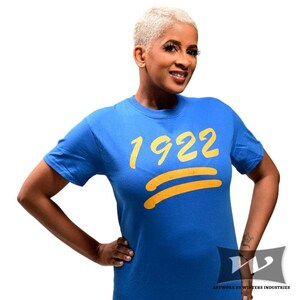 May include: A royal blue t-shirt with a yellow graphic of the number 1922 and two yellow lines.