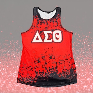 Puede incluir: Camiseta de tirantes roja con un patrón de salpicaduras en blanco y negro y las letras "ΔΣΘ" en blanco.