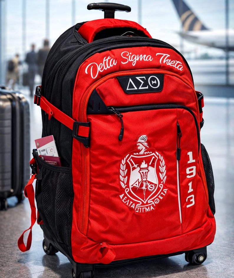 May include: A red and black rolling backpack featuring the text Delta Sigma Theta, the Greek letters &Delta;&Sigma;&Theta;, and a crest emblem. The bag includes the year 1913 printed vertically on the front, a retractable handle, wheels, and side mesh pockets.
