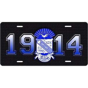 May include: Black license plate with blue and white text and a crest. The text reads "1914" and "ΦΒΣ Founded 1914".