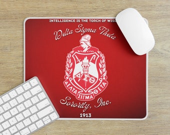May include: Red mouse pad with a white Delta Sigma Theta Sorority, Inc. logo and the text "Intelligence is the torch of wisdom". The logo features a shield with a torch, a laurel wreath, and the Greek letters Delta Sigma Theta. The text "1913" is below the logo.