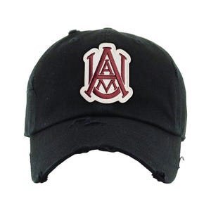 May include: Black distressed baseball cap with a maroon and white embroidered patch featuring the letters "A" and "M". The cap has a curved brim and a worn, vintage look.